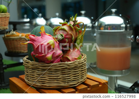 Dragon fruit and melon in a wicker basket on a wooden table Dragon fruit and melon in a wicker basket on a wooden table 116527998