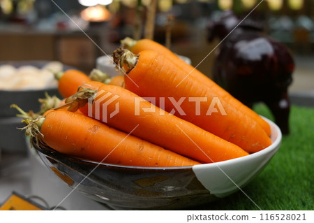 Fresh carrots in a bowl on the table 116528021