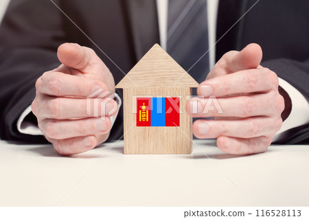 Businessman hand holding wooden home model with Mongolian flag. insurance and property concepts 116528113