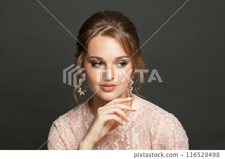 Woman with updo hairstyle and makeup on black background. Young female model portrait Woman with updo hairstyle and makeup on black background. Young female model portrait 116528498