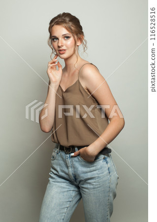 Portrait of fashion model woman standing against white studio wall background Portrait of fashion model woman standing against white studio wall background 116528516