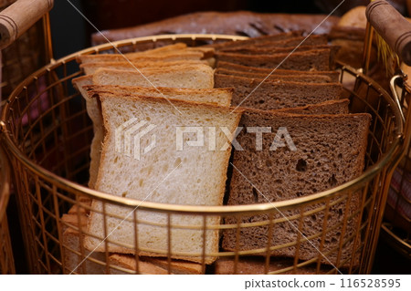 Sliced bread in a basket on a table in a bakery 116528595