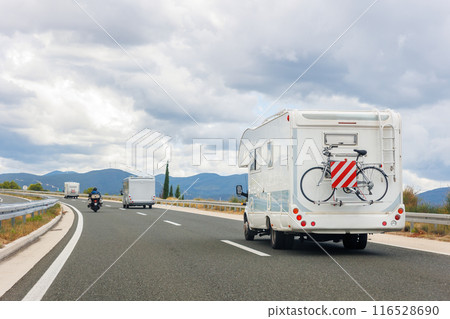 Scenic view group modern white family rv camper van vehicle drive Europe highway road alpine mountain cloud summer day overcast cloudy sky. Rving lifestyle travel community adventure  trip journey 116528690