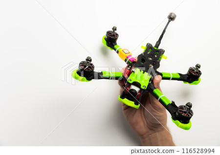 Hand holding fpv racing drone on white background. Launching and checking the aircraft Hand holding fpv racing drone on white background. Launching and checking the aircraft 116528994