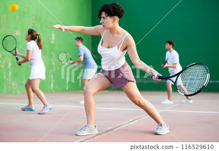 Woman pelota player hitting ball with racket Woman pelota player hitting ball with racket 116529610
