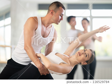 Ballet dancer providing support of female partner in challenging movements 116529784