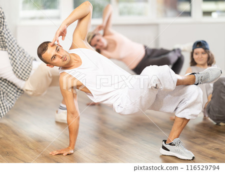 Group of young friends learn group dances - hip-hop and breakdance in dance studio Group of young friends learn group dances - hip-hop and breakdance in dance studio 116529794