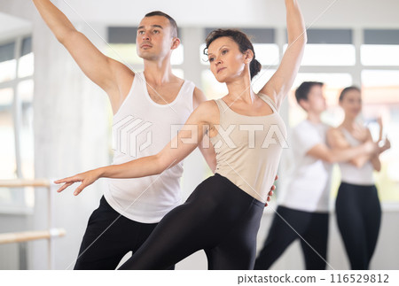 Ballet partners mastering paired technique at group class in studio 116529812