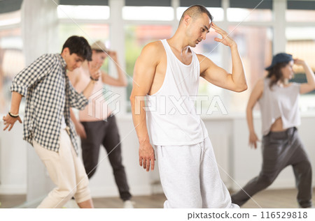 Young guy practicing hip hop slide moves in training hall Young guy practicing hip hop slide moves in training hall 116529818