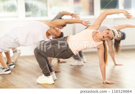 Group of young friends learn group dances - hip-hop and breakdance in dance studio 116529864