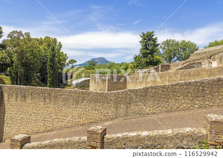 View of the historic ruined city of Pompeii in Italy with the volcano Vesuv View of the historic ruined city of Pompeii in Italy with the volcano Vesuv 116529942
