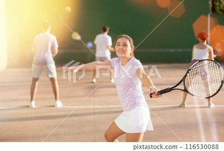 Woman serving ball during frontenis game outdoors Woman serving ball during frontenis game outdoors 116530088