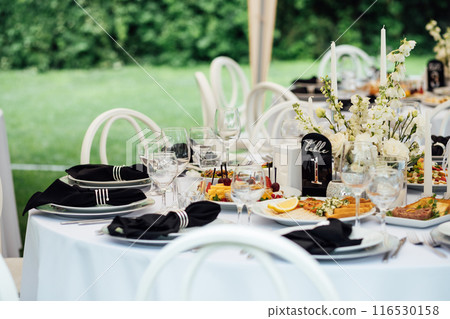 Luxurious restaurant. Luxurious interior, white tables, serving dishes and glasses for guests 116530158