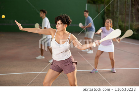 Woman playing Basque pelota on outdoor pelota court 116530228
