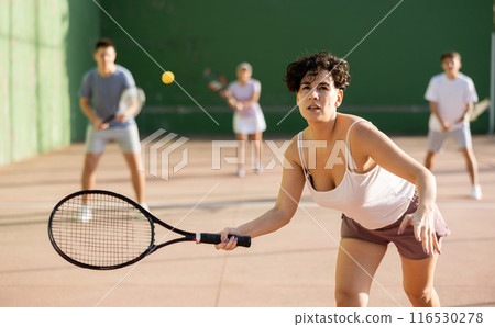 Woman serving ball during frontenis game outdoors Woman serving ball during frontenis game outdoors 116530278