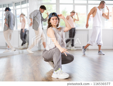 Young girl breakdancing against background of group members 116530377