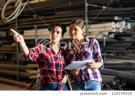 Women dicsussing stock control in warehouse Women dicsussing stock control in warehouse 116530458