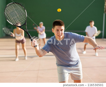 Sports active man during friendly doubles couple match. Two men playing frontenis together outdoor 116530501