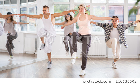 Young girl standing performs basic hip hop movements in front of group of students Young girl standing performs basic hip hop movements in front of group of students 116530502