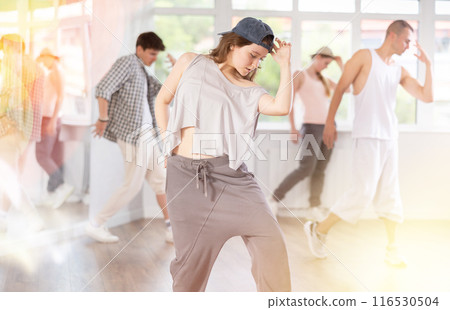Young girl practicing hip hop slide moves in training hall 116530504