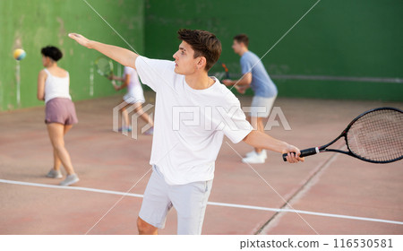 Hispanic guy playing frontenis on open court on summer day 116530581