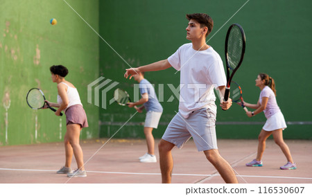 Hispanic guy playing frontenis on open court on summer day 116530607