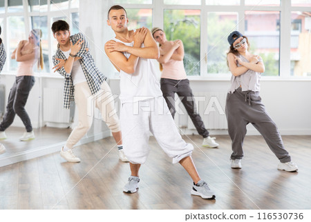 Group of young people perform choreographic exercises and teaches energetic mobile social dance waacking together Group of young people perform choreographic exercises and teaches energetic mobile social dance waacking together 116530736