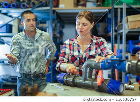 Woman fixing and assembling plumbing fixture in workshop Woman fixing and assembling plumbing fixture in workshop 116530757