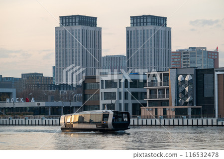 Electric river tram on the Moskva River at sunset on an autumn evening. Electric river tram on the Moskva River at sunset on an autumn evening. 116532478