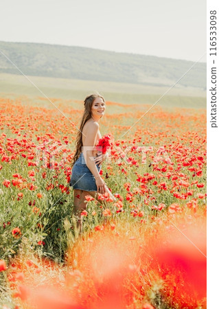 Woman poppies field. portrait happy woman with long hair in a poppy field and enjoying the beauty of nature in a warm summer day. 116533098