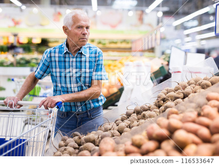 Elderly retired man buying potato in grocery department of supermarket Elderly retired man buying potato in grocery department of supermarket 116533647