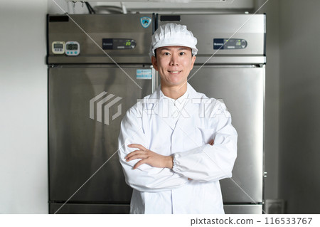 亞洲男子在廚房交叉雙臂穿著衛生服 116533767