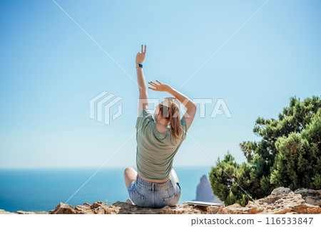 Woman tourist sky sea. Happy traveller woman in hat enjoys vacation raised her hands up 116533847