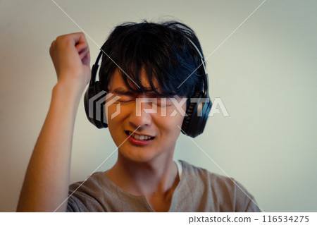 Young man listening to music with headphones Young man listening to music with headphones 116534275