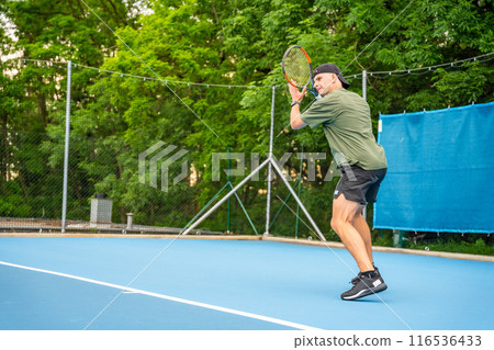 Professional male tennis player playing the tennis on outside court Professional male tennis player playing the tennis on outside court 116536433