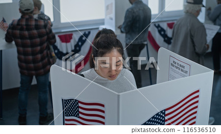 Asian woman comes to vote in booth in polling station office Asian woman comes to vote in booth in polling station office 116536510