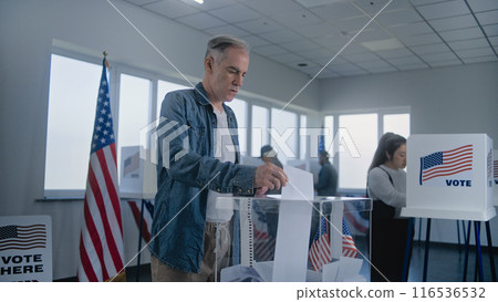 Adult Caucasian man puts bulletin paper in box after voting Adult Caucasian man puts bulletin paper in box after voting 116536532