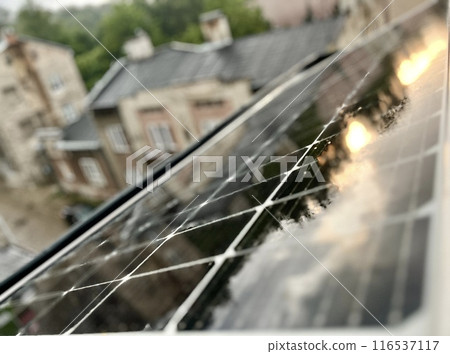 Solar panels installed on the roof of a house in the city in the rain. Solar panels installed on the roof of a house in the city in the rain. 116537117