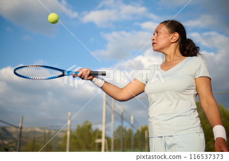 Woman plays tennis on the court 116537373