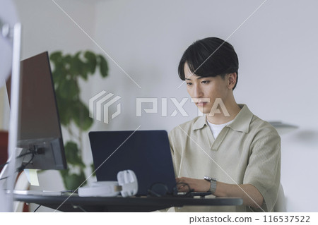 A young man working on a personal computer A young man working on a personal computer 116537522