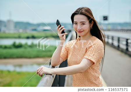 A young woman operating a smartphone 116537571