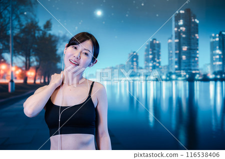 Woman exercising at night while listening to music 116538406