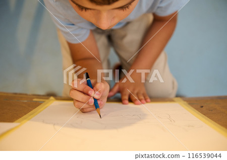 Child drawing in art class, creativity and imagination fostered by hands-on learning 116539044
