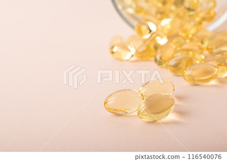 Omega 3 fish oil on pink background. Vitamins in soft capsules, cod liver oil closeup. Concept of healthcare, supplements, vitamin D, treatment of diseases. Copy space, banner. High quality photo Omega 3 fish oil on pink background. Vitamins in soft capsules, cod liver oil closeup. Concept of healthcare, supplements, vitamin D, treatment of diseases. Copy space, banner. High quality photo 116540076