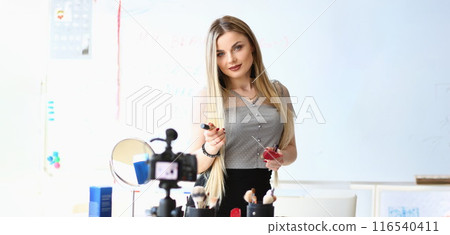 Beautiful woman blogger present beauty products for facial makeup on camera 116540411