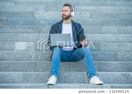 photo of man webinar online on laptop with coffee. man webinar online outdoor. photo of man webinar online on laptop with coffee. man webinar online outdoor. 116540524