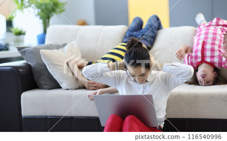 Tired mom trying to concentrate and work kids going crazy and jump Tired mom trying to concentrate and work kids going crazy and jump 116540996