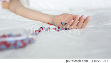 Young woman committing suicide by overdosing on medication Young woman committing suicide by overdosing on medication 116541013