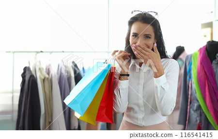 Happy smiling woman holding packages with purchases Happy smiling woman holding packages with purchases 116541415