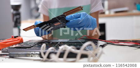 Tech fixes motherboard of laptop in service center Tech fixes motherboard of laptop in service center 116542008